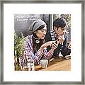 Asian Couple Looking At Their Mobile Phones. Framed Print