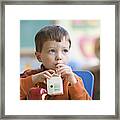 Caucasian Boy Eating Lunch In Classroom Framed Print