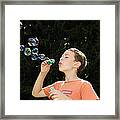 Child Playing With Bubbles Framed Print