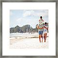 Family With One Daughter Walking On Sandy Beach Framed Print