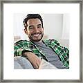 Mixed Race Man Smiling On Sofa Framed Print