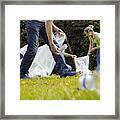 People Cleaning Up Litter On Grass Framed Print