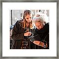 Senior Lady And Grandchild Looking At Smartphone Framed Print