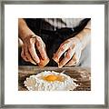 Woman Adds An Egg To The Flour Framed Print