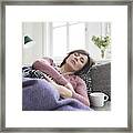 Woman With Stomach Ache Lying On The Sofa Framed Print