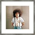 Young Boy Standing In Front Of A Wall Framed Print