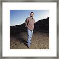Young Caucasian Man With Jeans And Red Long Sleeved Shirt Stands Outdoors Looking Into The Camera Framed Print