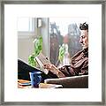 Young Man Reading A Book At Home Framed Print