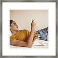 Young Woman Checking Phone In Bunk Bed Framed Print