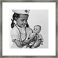 Girl Playing Nurse With Doll, C.1960s Framed Print