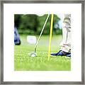 Golfer Putting Ball In The Hole On A Golf Course. Framed Print