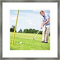 Senior Man Putting A Ball In The Hole. Framed Print