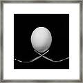 White Egg  Resting On Two Metal And Shiny Forks On A Black Backg Framed Print