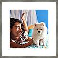 A Little Girl Has Fun With Her White Pomeranian Puppy Framed Print