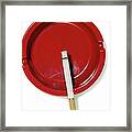 A Red Ashtray With A Burning Cigarette Framed Print