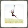 Low Angle View Of Cheerful Woman Swinging On Rope Against Clear Sky Framed Print