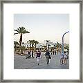 People Walking On Stone Plaza Near Palm Framed Print