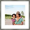 Portrait Of Girlfriend Embracing Man While Standing At Beach Against Sky Framed Print