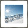 Skier Stands On Summit As Wind Blows Framed Print