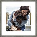 Woman Embracing Dog While Standing Against Hudson River Framed Print