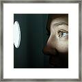 Woman Looking Through Illuminated Peep Framed Print