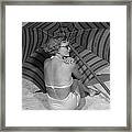 Woman Sitting On Beach Under Umbrella Framed Print