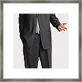 A Young Handsome Caucasian Businessman With Short Dark Hair Dressed In A Dark Grey Suit Looking Into The Camera With A Hand Exended In Conversational Gesture Framed Print