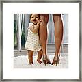 Baby Girl (6-9 Months) Standing On Rug, Holding Onto Mother's Legs Framed Print