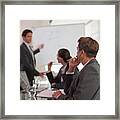 Businessman Talking To Co-workers In Conference Room Framed Print