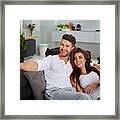 Couple Relaxing On A Sofa Framed Print