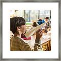 Elementary Schoolboy Ready To Throw Paper Airplane In The Classroom. Framed Print