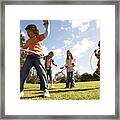 Five Children (7-12) Playing With Plastic Hoops In Park Framed Print