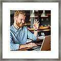 Happy Young Businessman Waving To An Online Client. Framed Print