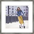 Happy young woman riding electric scooter on a bridge Framed Print