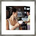 Man And Woman Preparing Breakfast And Smiling At One Another Framed Print