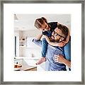 Mature Father Giving Piggyback Ride To Small Daughter Indoors At Home. Framed Print