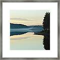Mist Is Rising Over A Quiet Forest Lake At Dusk Framed Print