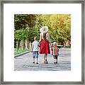 Mum And Two Sons Walking In The Park, Sunny Day. View From The Back Framed Print