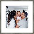 Portrait Of Young Couple With Toddler Girl In The Morning Indoors In Bathroom At Home, Kissing. Framed Print