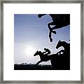 Silhouette Of Race Horses Jumping A Fence Framed Print