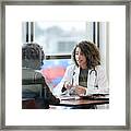Sitting In Office, Doctor Has Serious Conversation With Patient Framed Print
