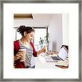 Smiling Woman With Coffee To Go At Desk At Home Framed Print