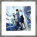 Three Young Women Office Workers Surrounding Male Colleague. Framed Print