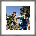 Two Young Women Planting Bulbs In Their Garden Framed Print