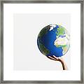 Woman Holding Globe In Raised Hands Against White Background, Close-up Framed Print