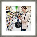 Woman Reading Food Item Label In Supermarket Framed Print