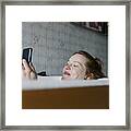 Woman Taking Bath And Smiling While Messaging Someone Framed Print