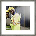 Young African American Men And Woman Worker Check And Control Loading Freight Containers By Use Computer Laptop At Commercial Shipping Dock Felling Happy. Cargo Freight Ship Import Export Concept Framed Print