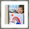 Young Boy Sticking His Drawing On Home Window During The Covid-19 Crisis Framed Print