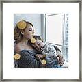 Young Woman Relaxing With Son By Window At Home Framed Print